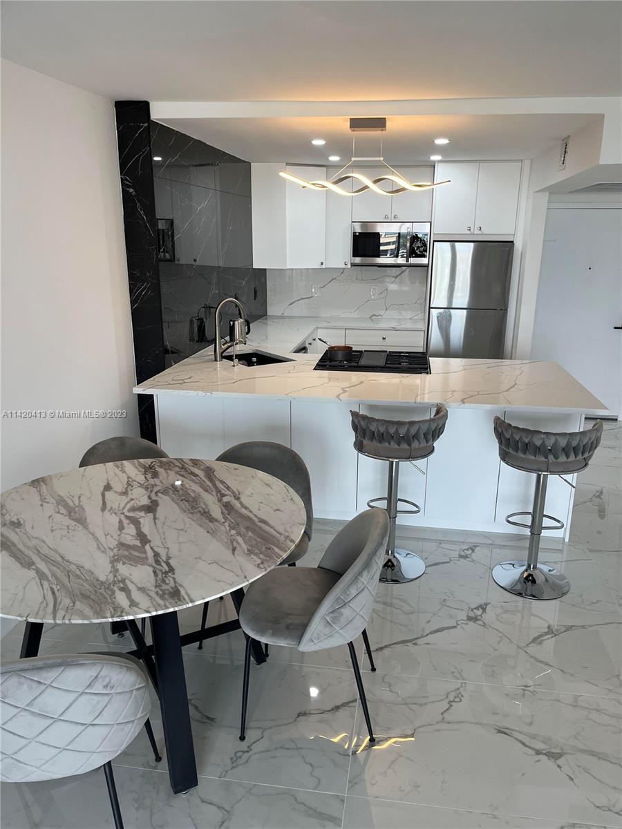 a kitchen with a table chairs sink and cabinets