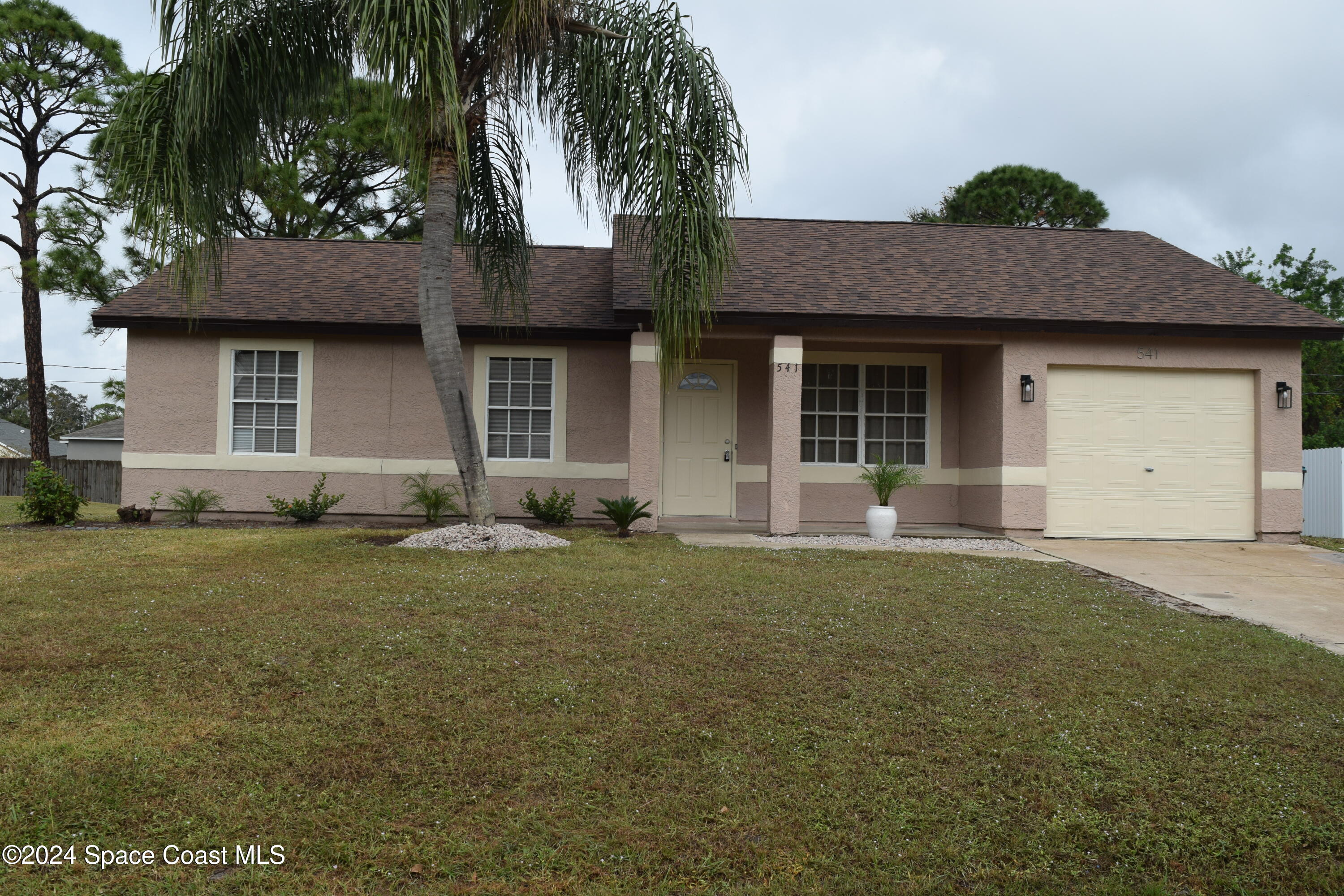 a front view of a house with a garden and yard