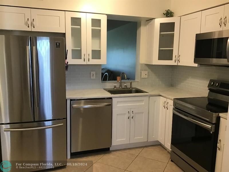 a kitchen with stainless steel appliances granite countertop a refrigerator stove and microwave