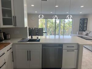 a kitchen with kitchen island a sink stainless steel appliances and cabinets