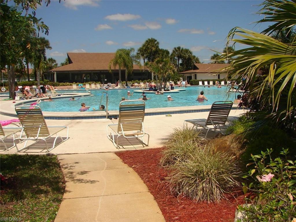 a view of a swimming pool with an outdoor seating and a pathway