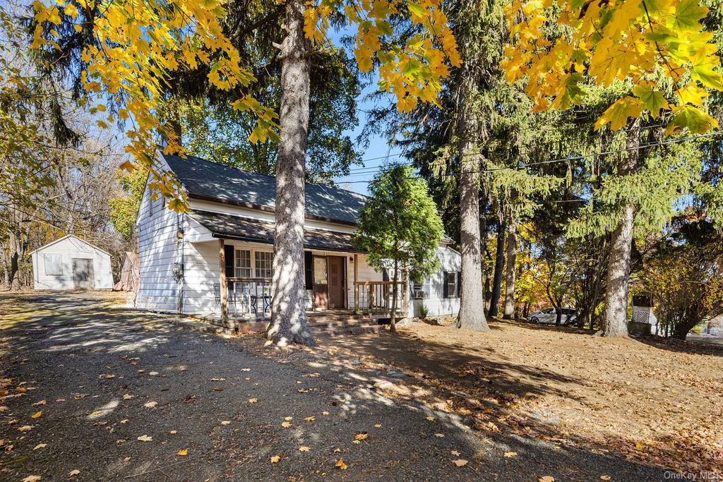 View of front of home with covered porch and an outbuilding