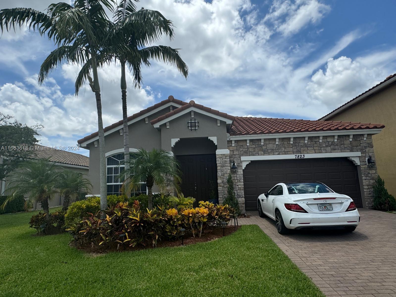 a car parked in front of a house with a garden