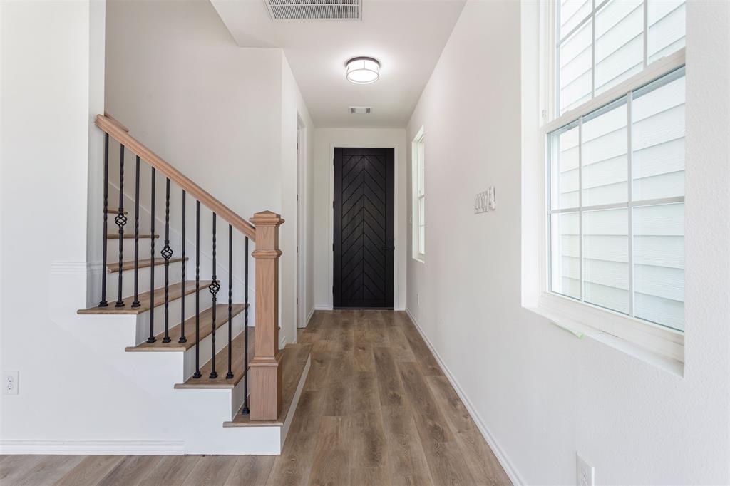 a view of a hallway with wooden floor and entryway