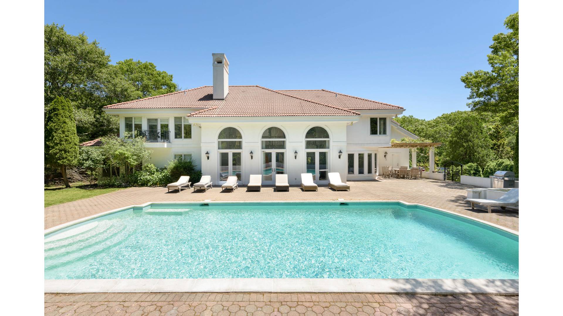 a front view of a house with swimming pool having outdoor seating