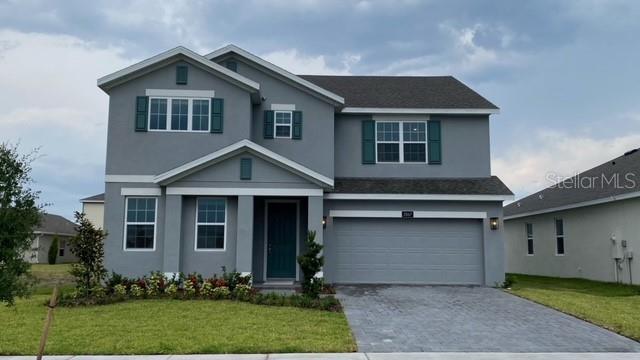 a front view of a house with a yard and garage