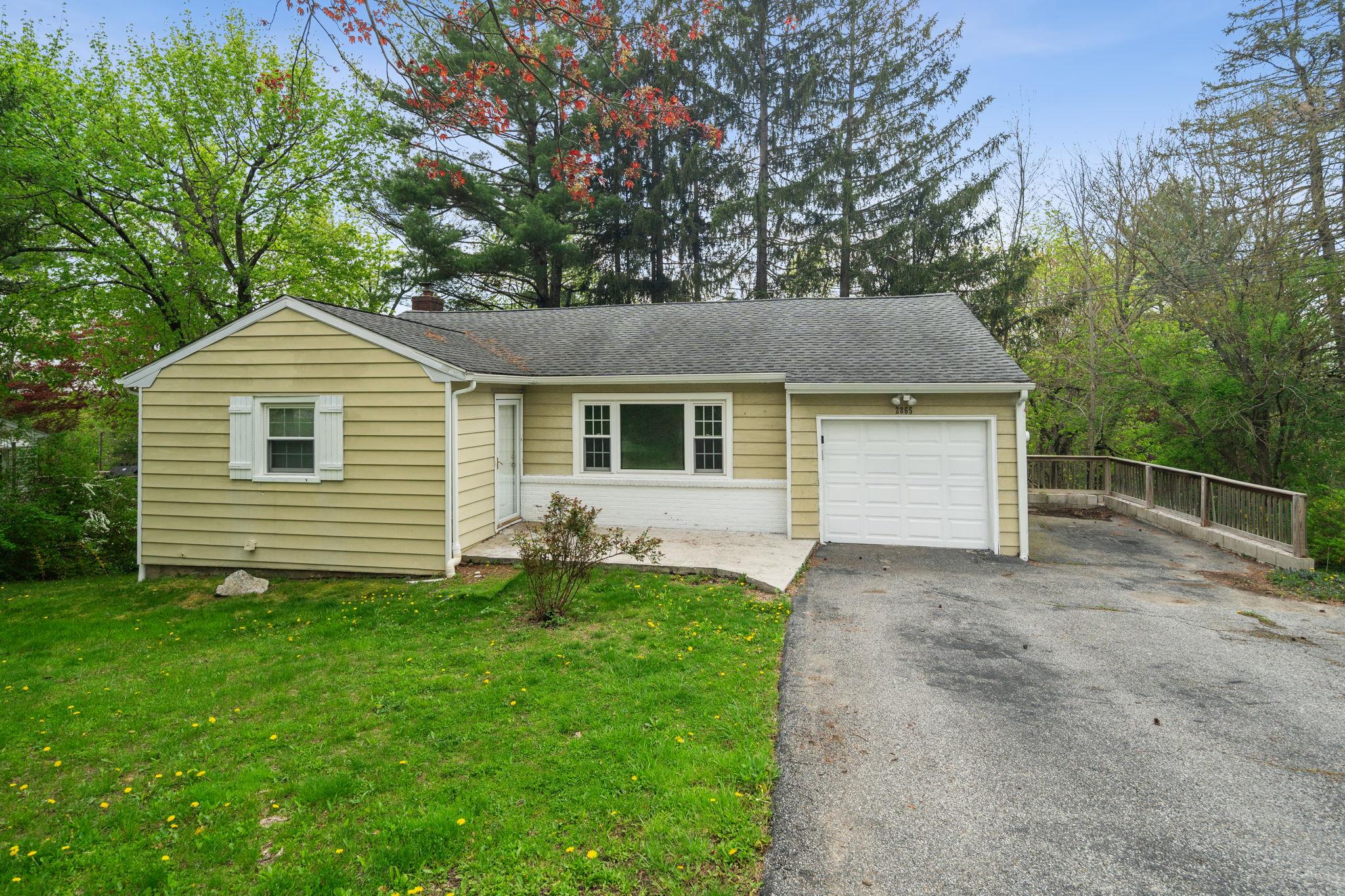 View of front of property featuring a garage and a front lawn