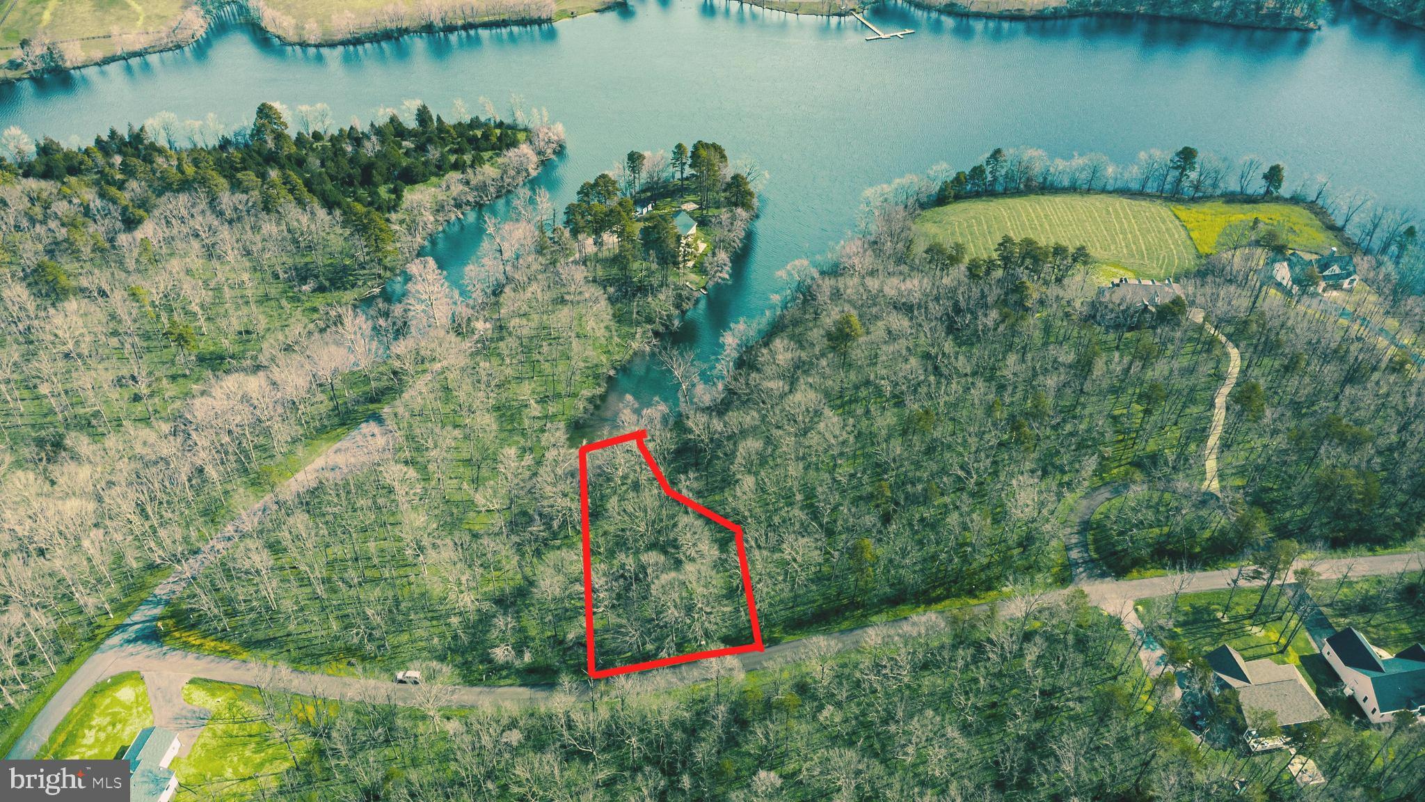 an aerial view of a house with a yard and lake view