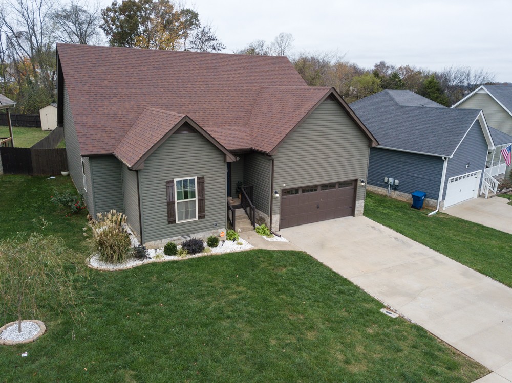 a front view of a house with a garden and yard