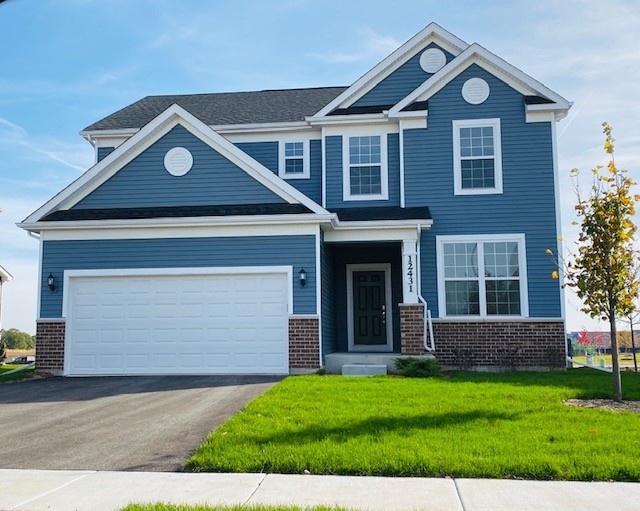 a front view of a house with a yard and garage