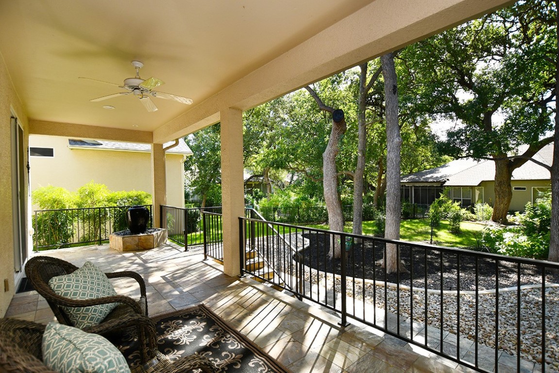 a view of a patio with couches chairs potted plants and a large tree