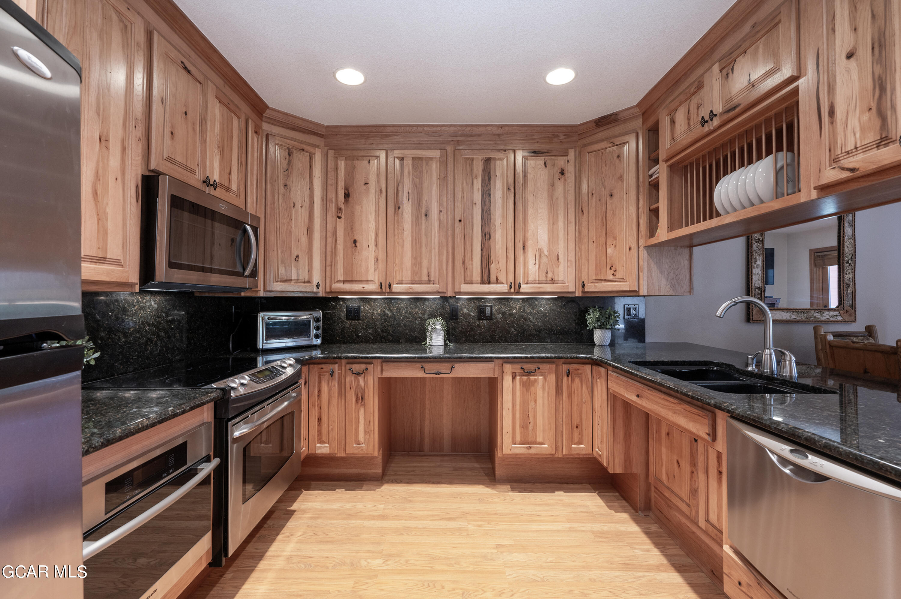 a kitchen with stainless steel appliances granite countertop a sink stove and cabinets