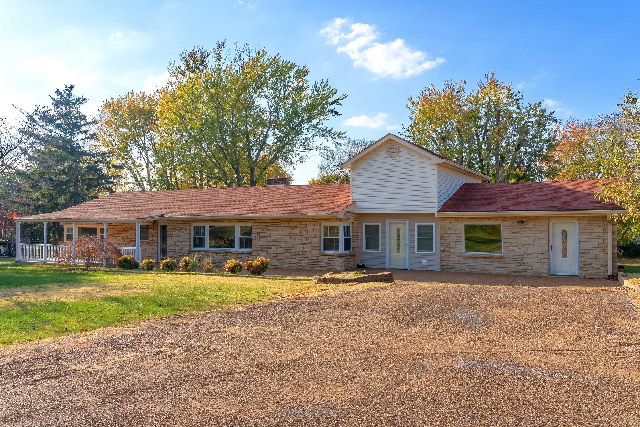 a front view of a house with a yard and trees