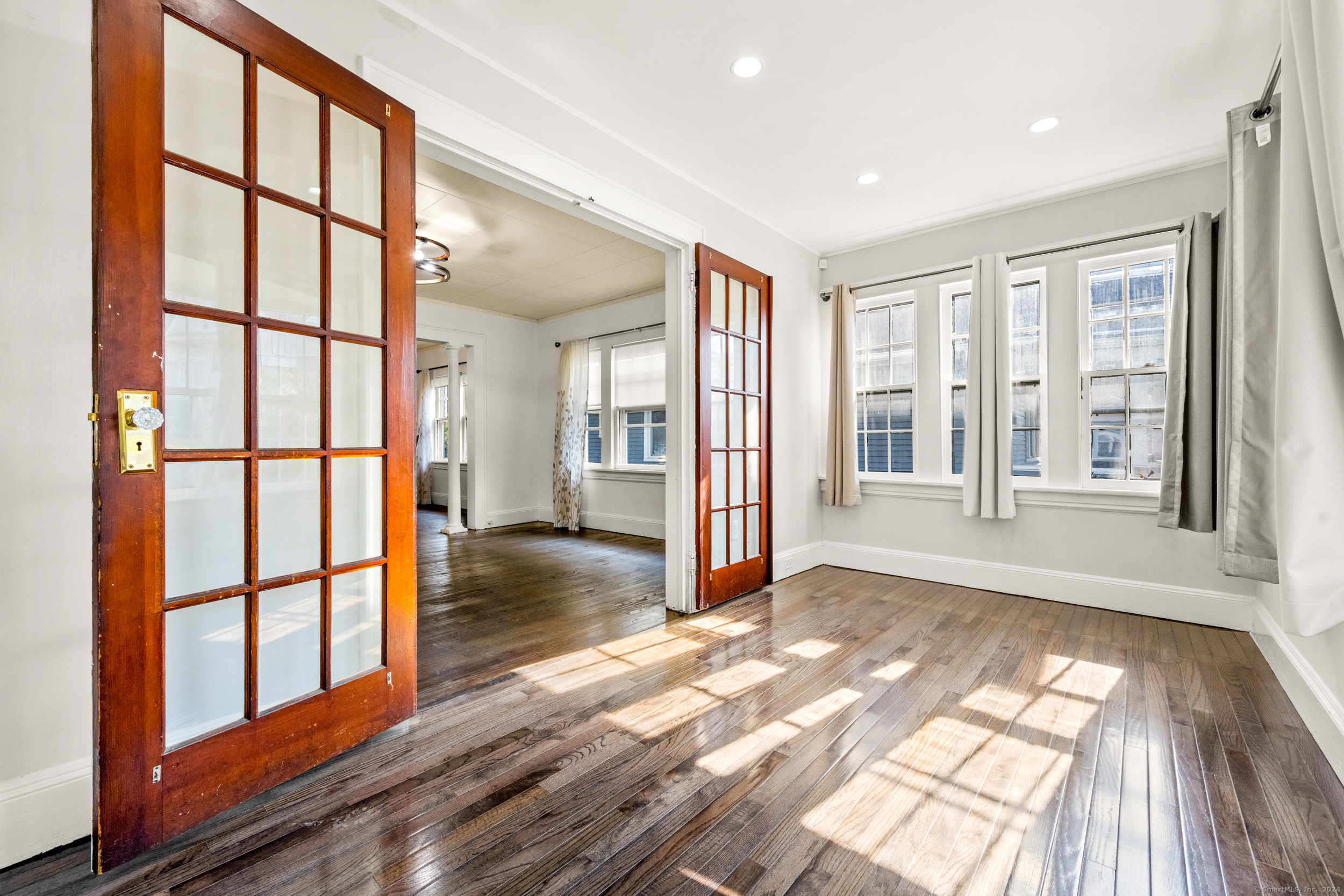 an empty room with wooden floor and windows