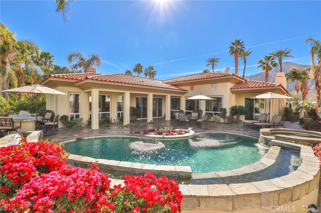 a view of a house with swimming pool and sitting area