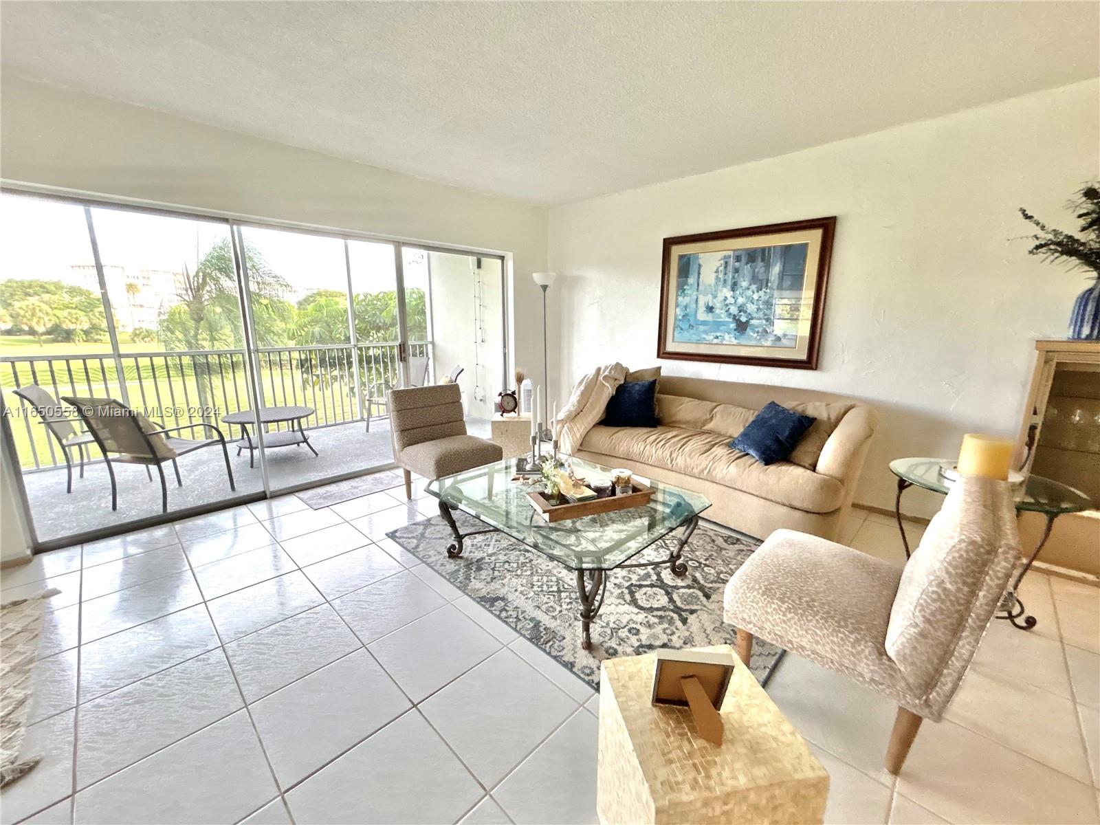 a living room with furniture and a floor to ceiling window