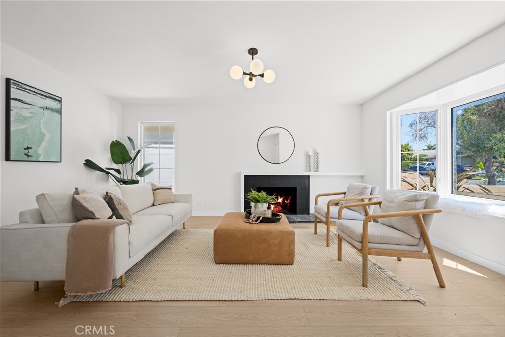 a living room with furniture a fireplace and a chandelier