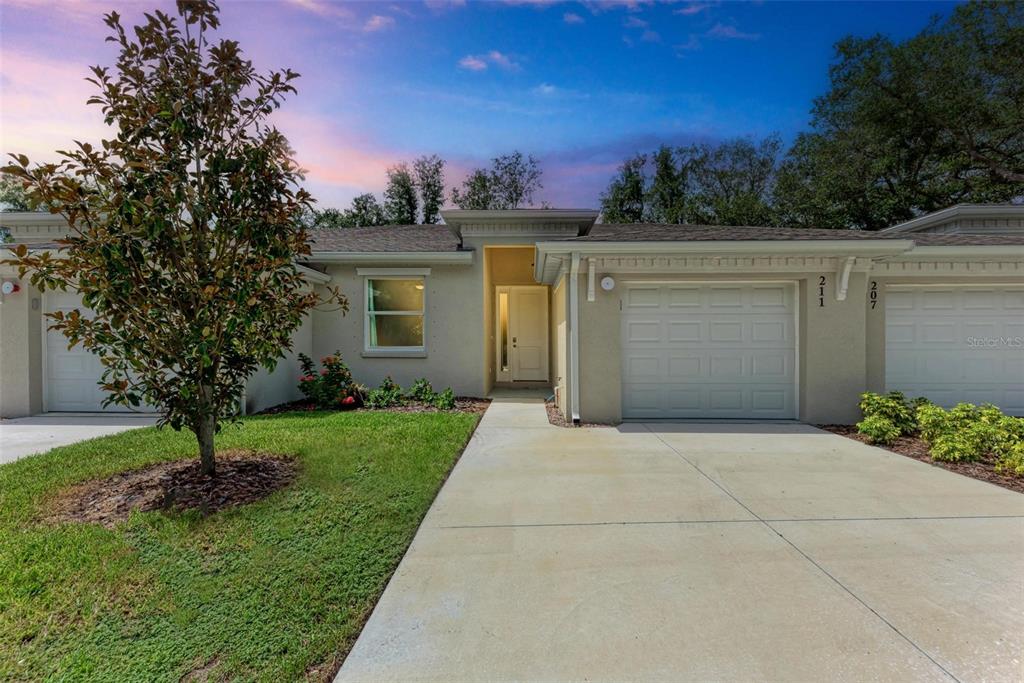 a view of a house with a yard and tree s