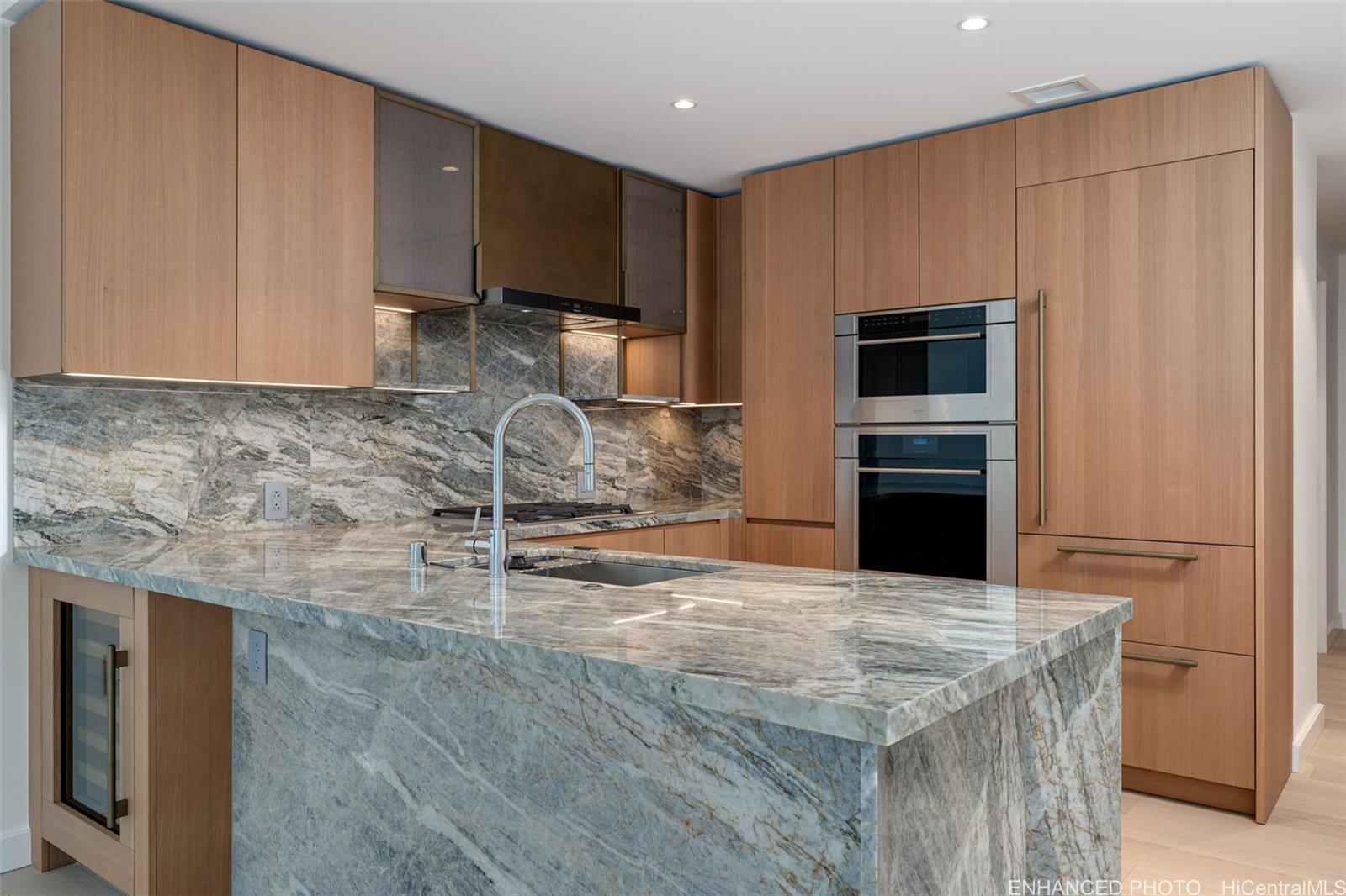 a kitchen with granite countertop a refrigerator stove and cabinets