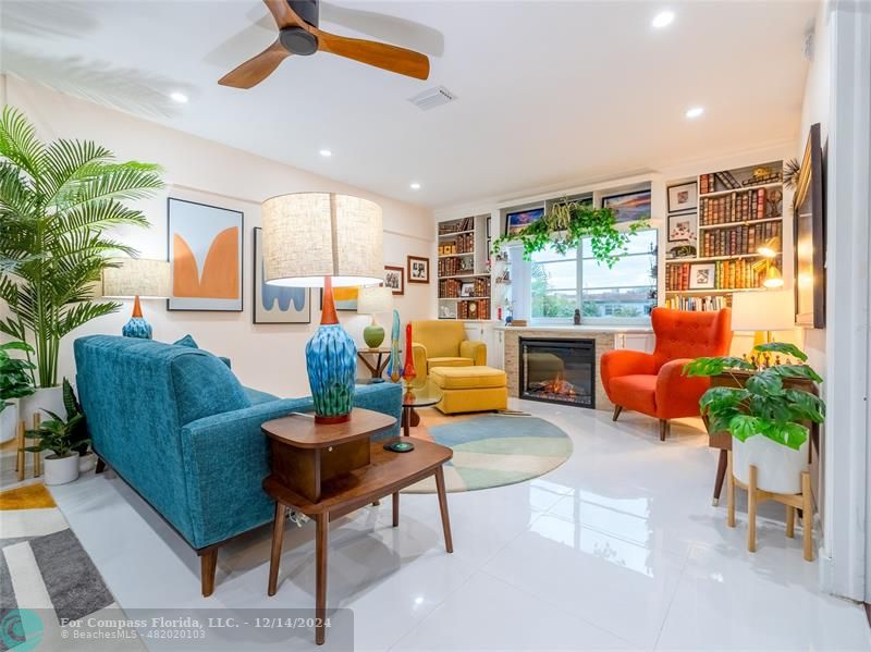 a living room with furniture fireplace and a large window