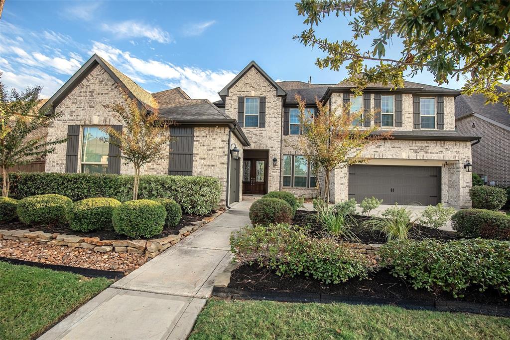 This is a two-story brick home featuring 4 bedroom (2 bedroom down), 4.5 bath, game room and beautiful landscaped front yard, an attached Three-car garage, and a welcoming entrance pathway.