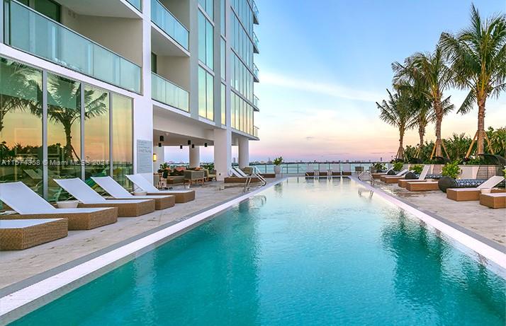 a view of swimming pool with outdoor seating and lake view