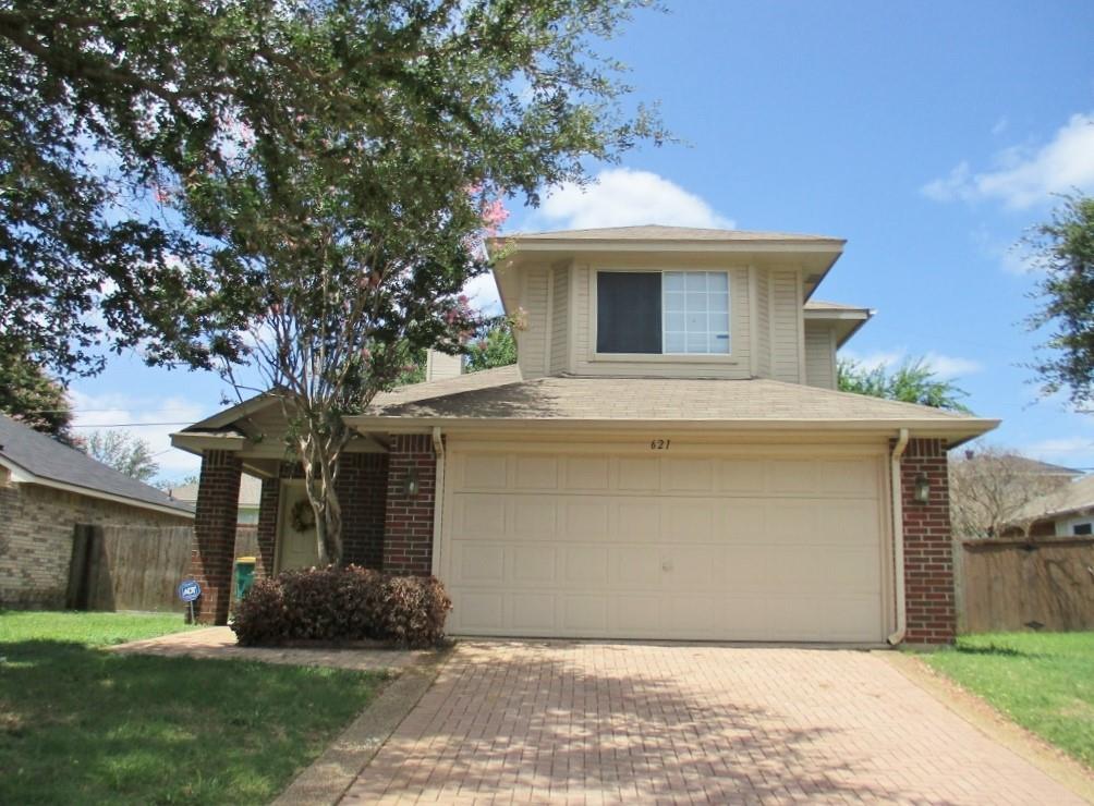 a front view of a house with a yard and a garage