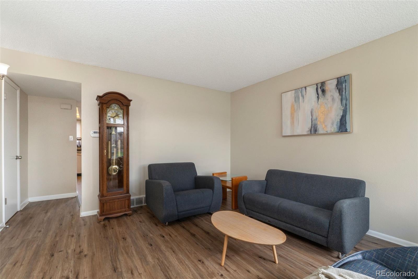 a living room with furniture and wooden floor