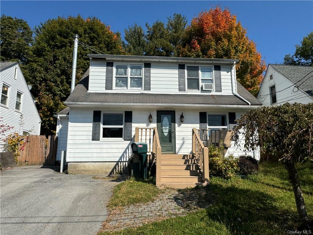 View of front of property with cooling unit and covered porch