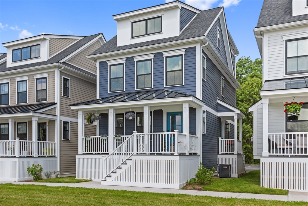 a front view of a house with a yard and deck