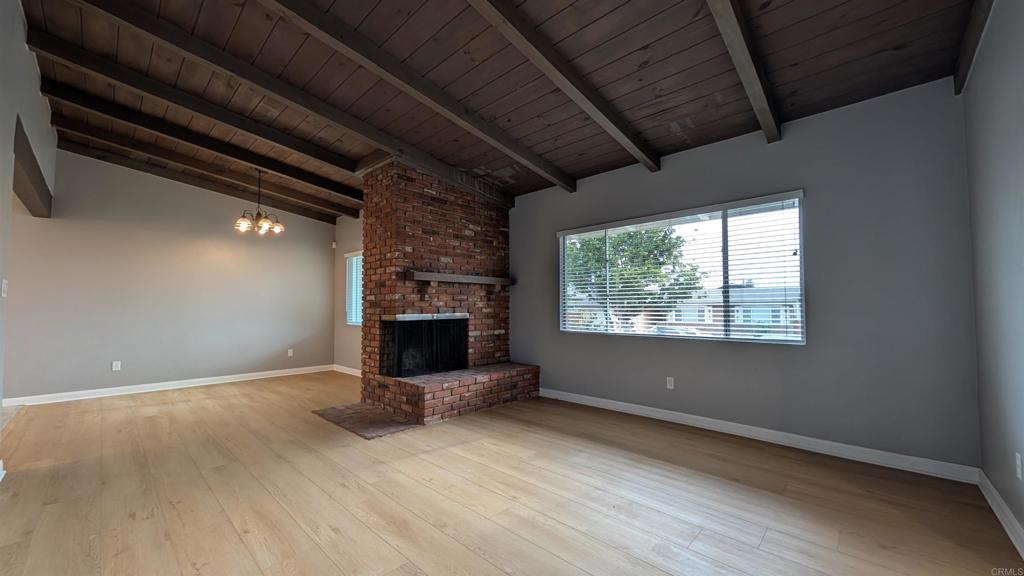 a view of empty room with fireplace and window