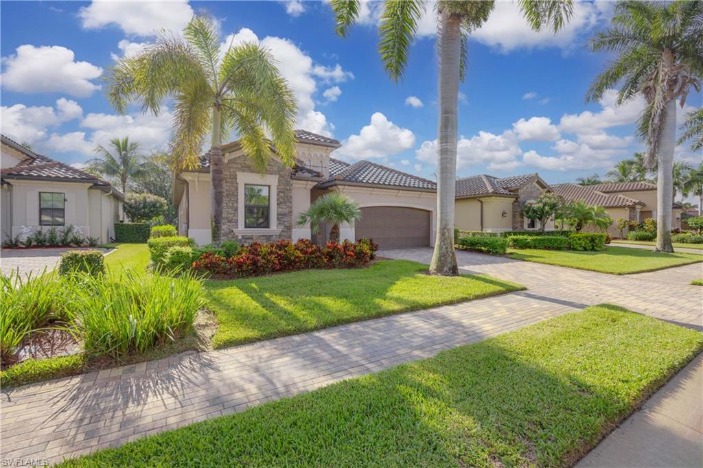 a view of a house with a big yard plants and palm trees