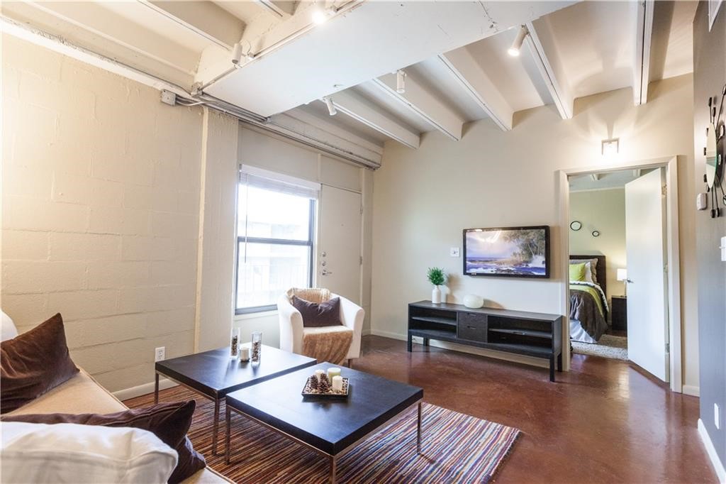 a living room with furniture a rug and a window