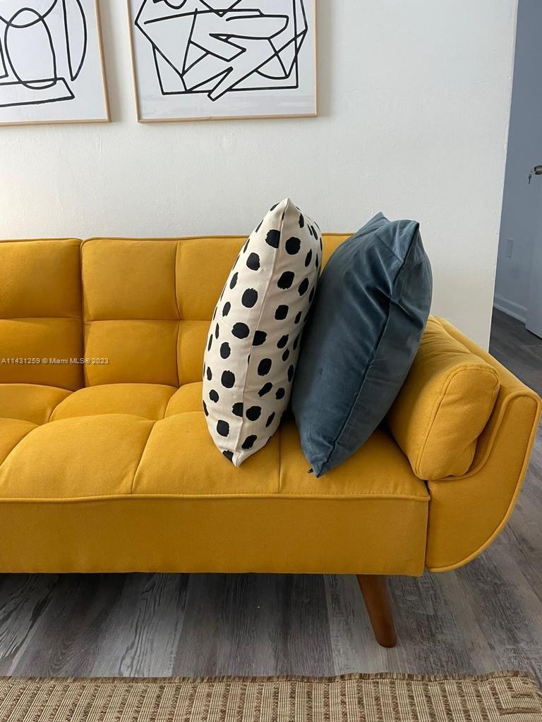 a living room with a couch and a wooden floor