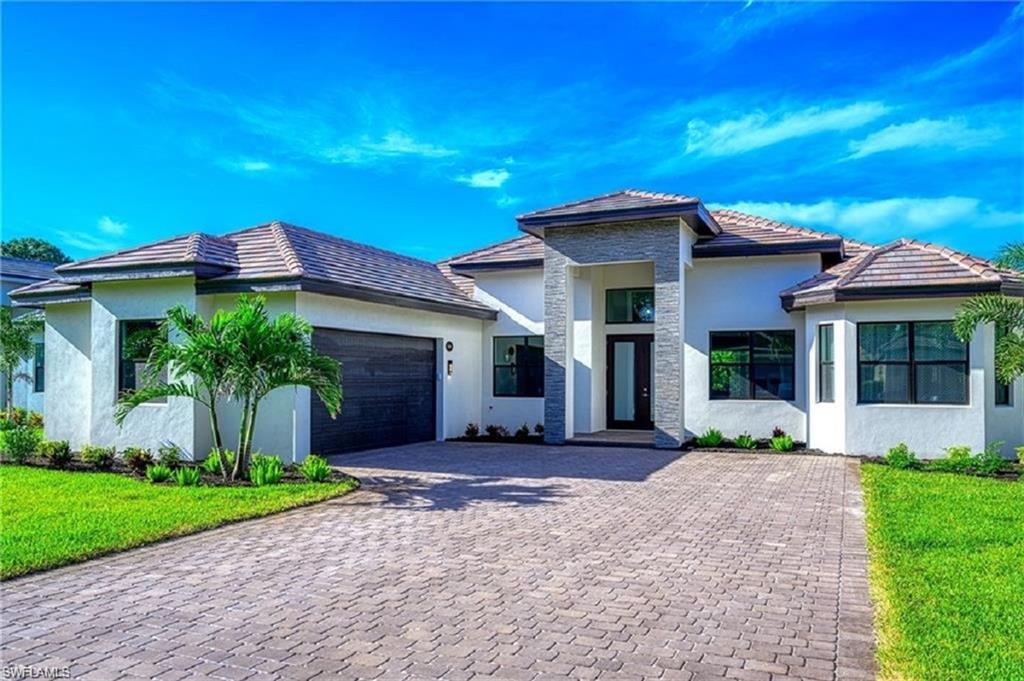 View of front of house with a front yard and a garage