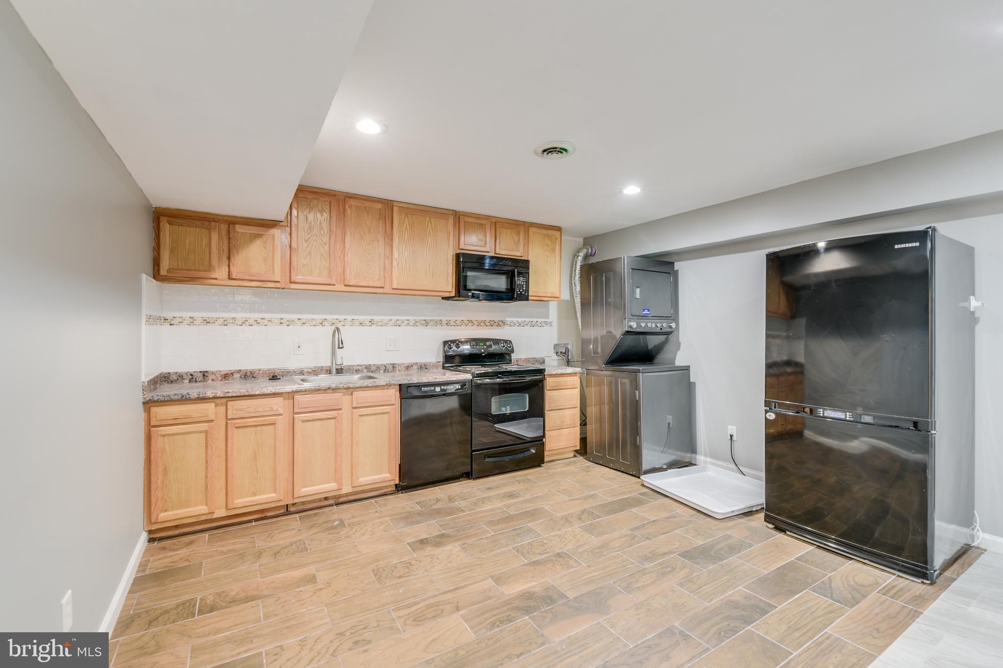 a kitchen with granite countertop a refrigerator stove top oven and sink