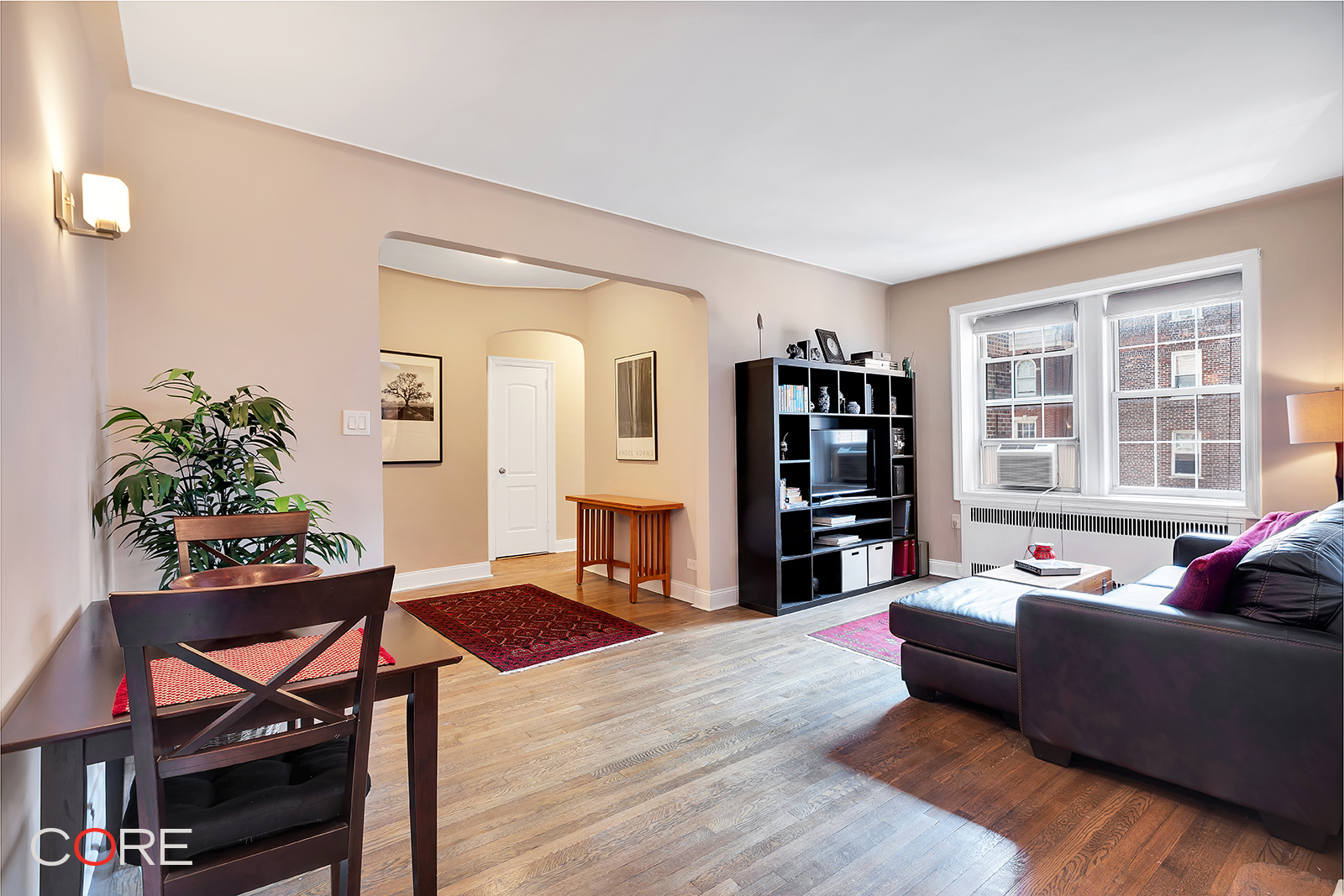 a living room with furniture a bookshelf and a window