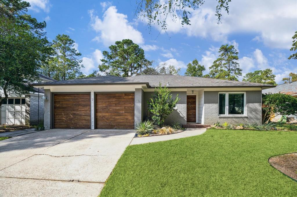 front view of a house with a yard and potted plants