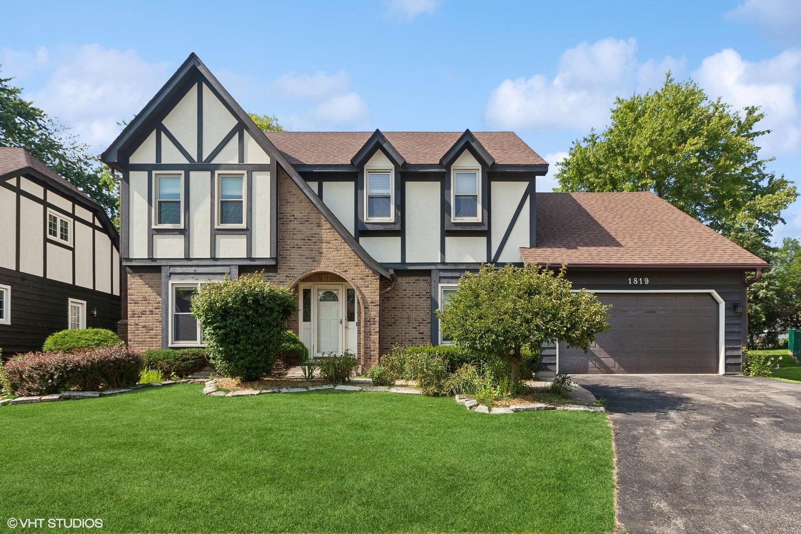 front view of house with a yard and potted plants