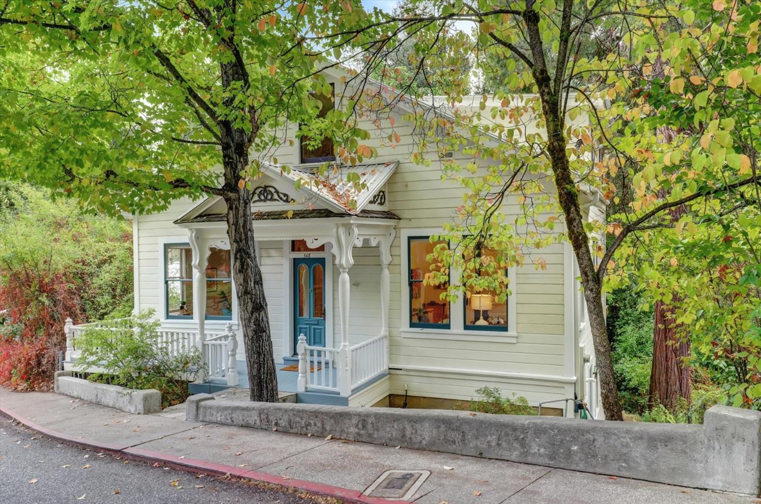 a front view of a house with a tree