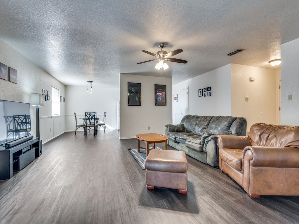 a living room with furniture and a wooden floor