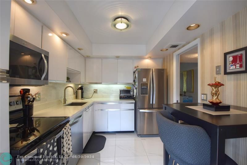 a kitchen with a sink microwave and cabinets