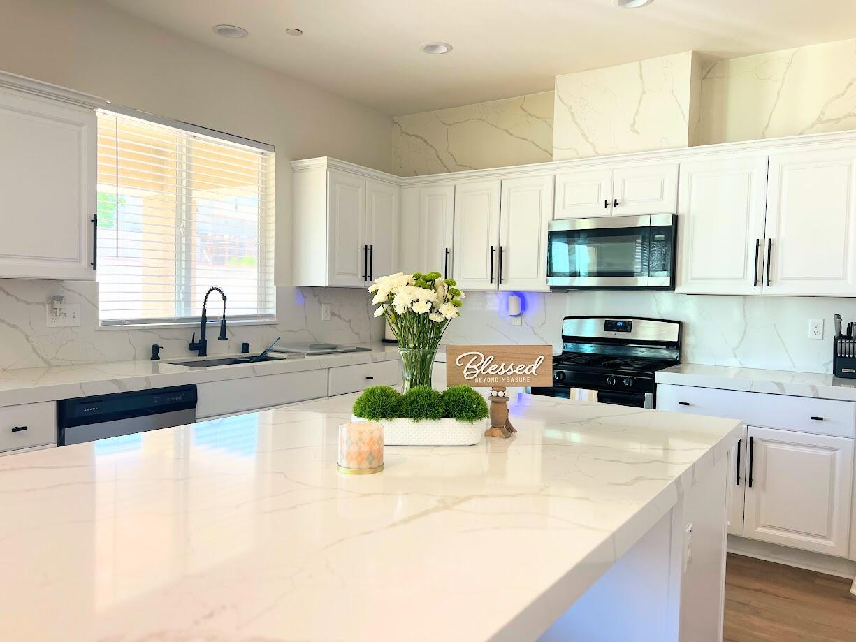 a kitchen with a sink a counter appliances and cabinets