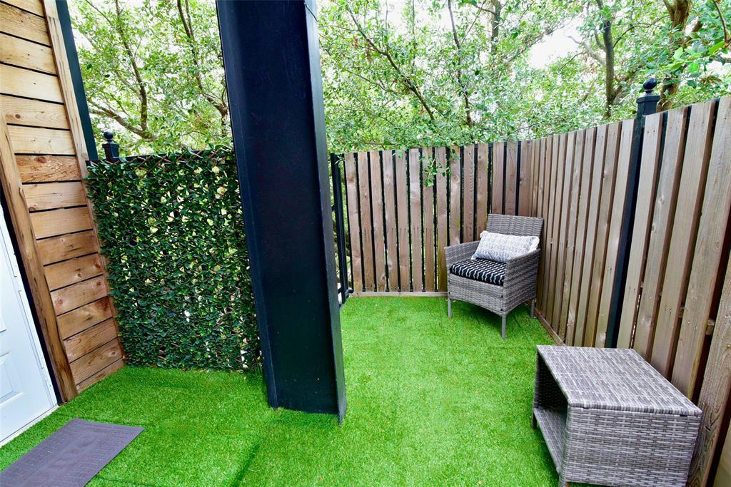 a view of a backyard with wooden fence and a bench