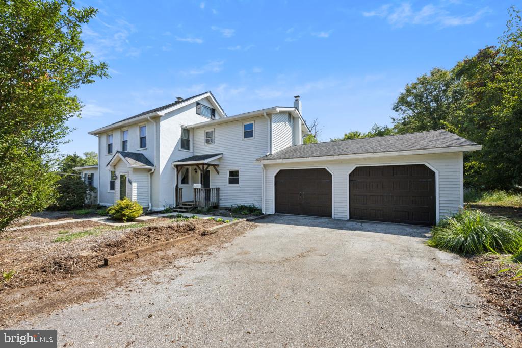 a front view of a house with parking yard and garage