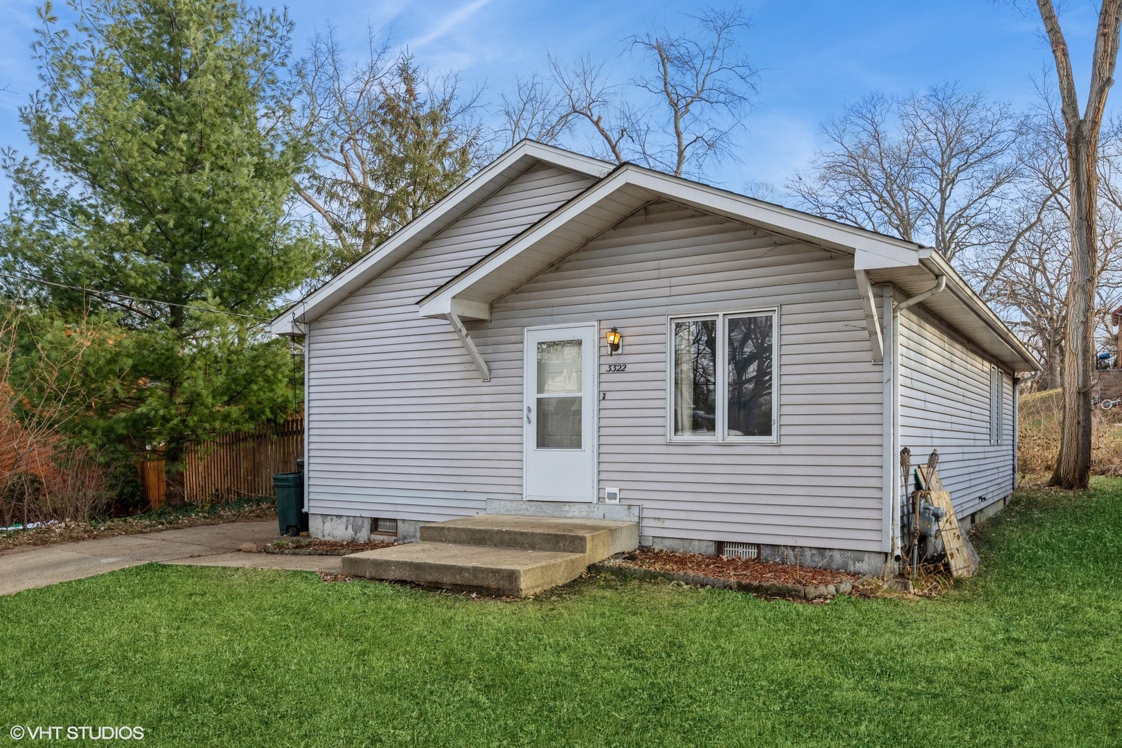 a front view of a house with a yard and trees