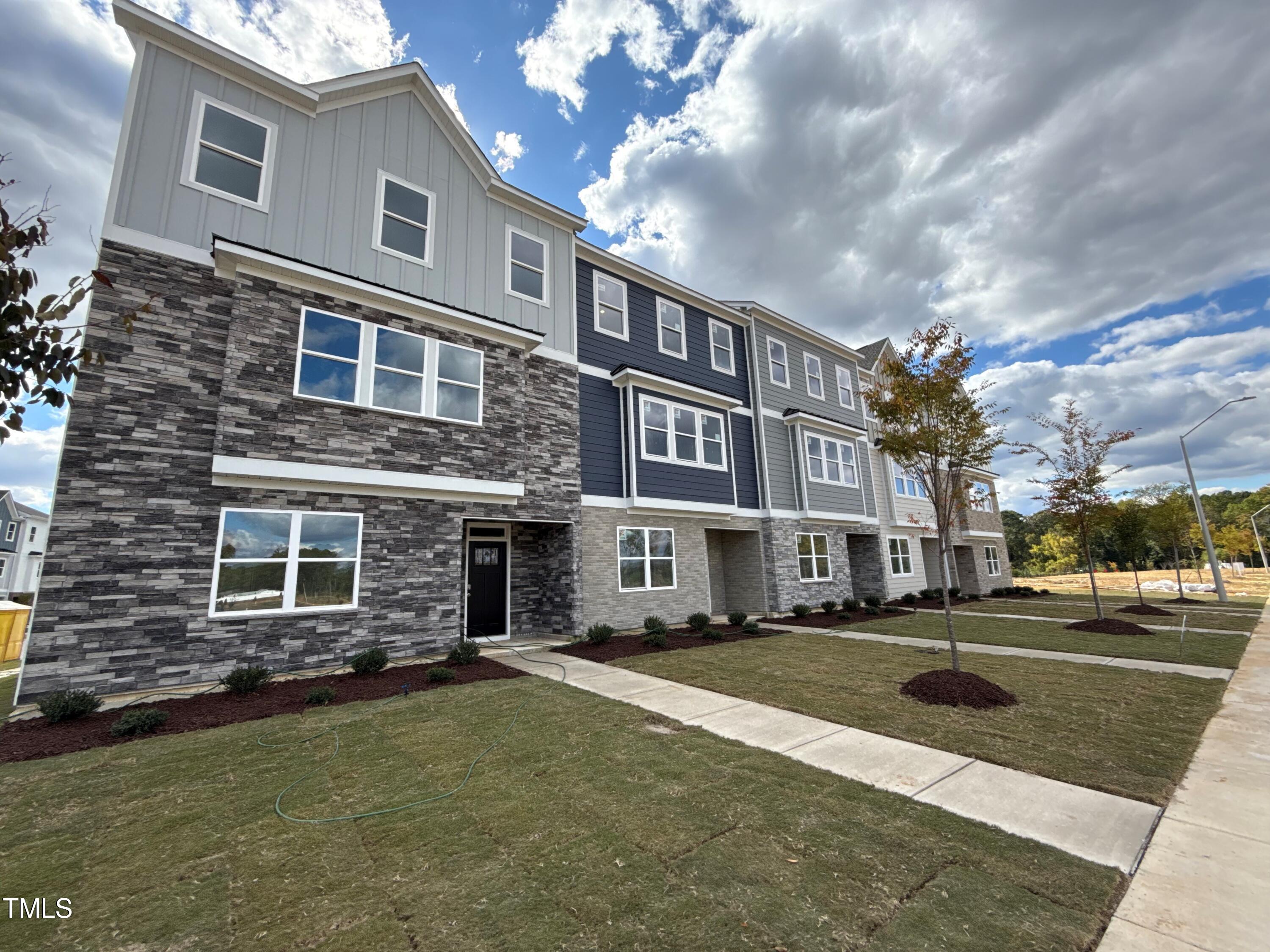 a front view of a residential apartment building with a yard