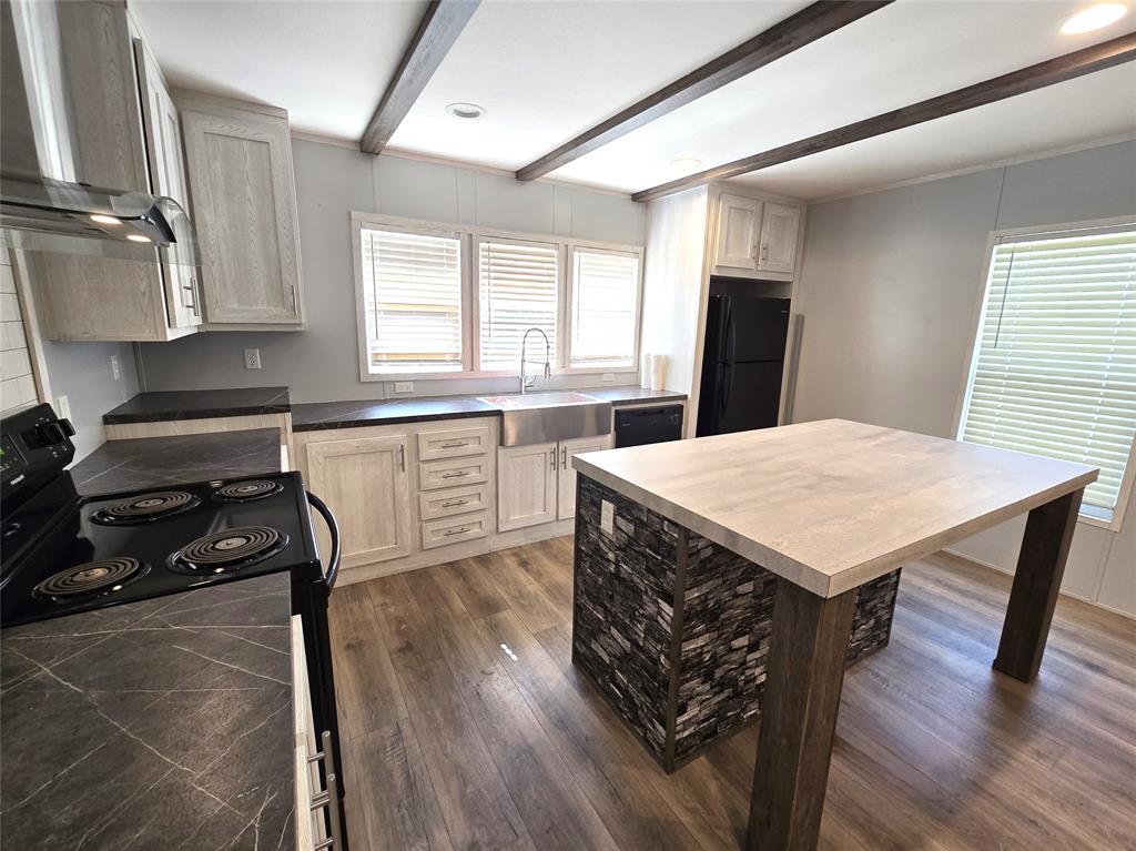 a kitchen with a table chairs refrigerator and window