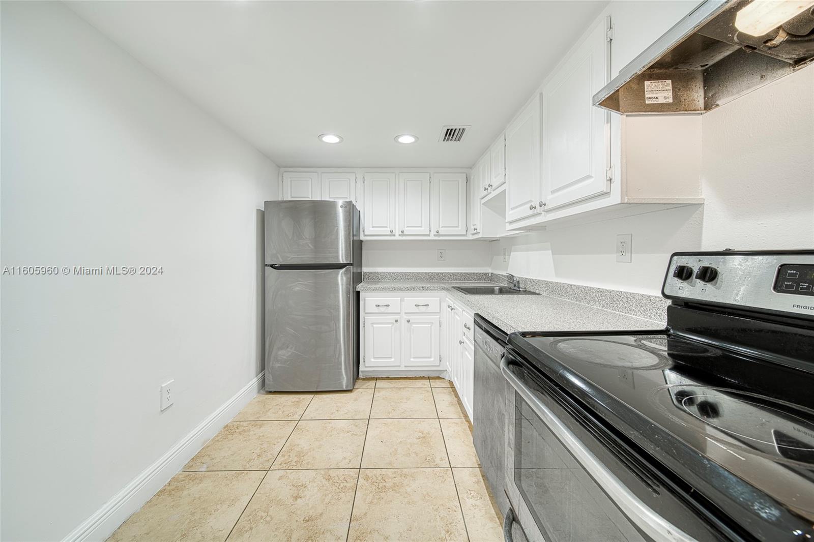 a kitchen with a sink stainless steel appliances and white cabinets