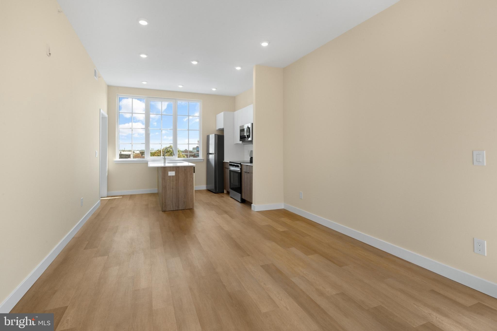 a view of a kitchen with a sink and dishwasher a refrigerator with wooden floor